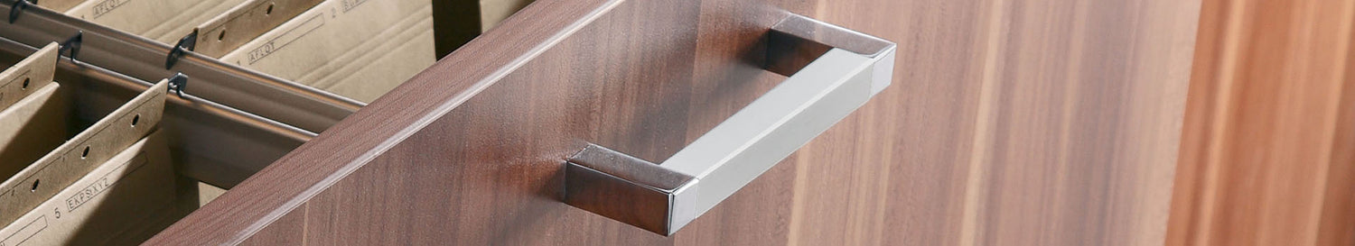 Nahaufnahme eines Holzschranks mit geöffneten Hängeregistraturen und silbernem Griff.