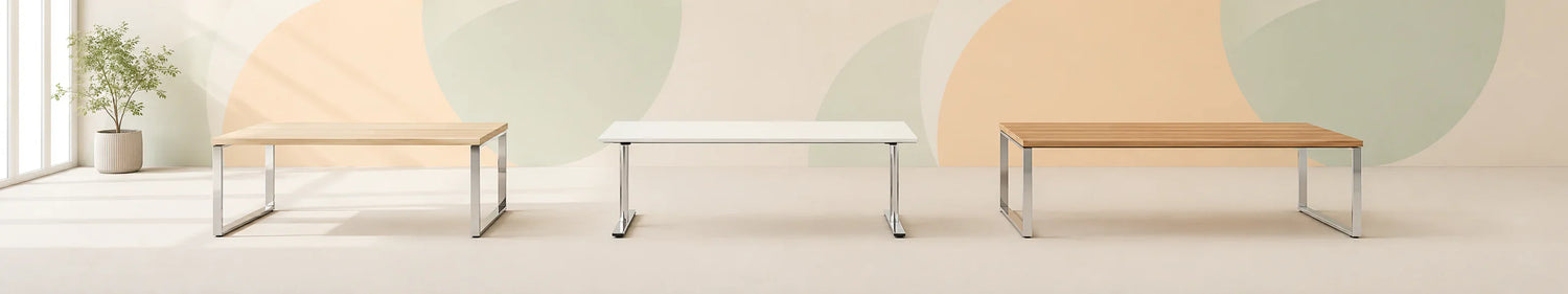 Bild von drei klassischen, hochwertigen Schreibtischen mit stabilen verchromten Kufen- und T-Fuss-Gestellen, verschiedenen Tischplatten in Holzoptik und Weiss, gebraucht für das moderne Büro.
