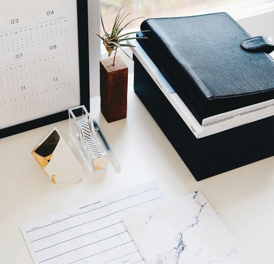 Blick auf einen Arbeitsplatz mit Kalender, Schreibutensilien und anderem Bürozubehör
